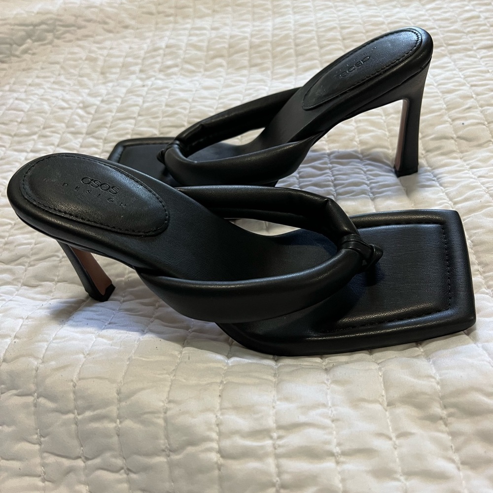 Square toe black thongs in faux leather.